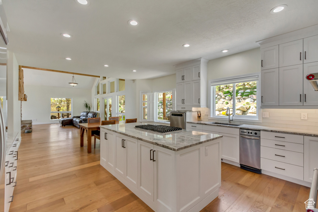Kitchen featuring a sink, stainless steel gas cooktop, a wealth of natural light, and open floor plan