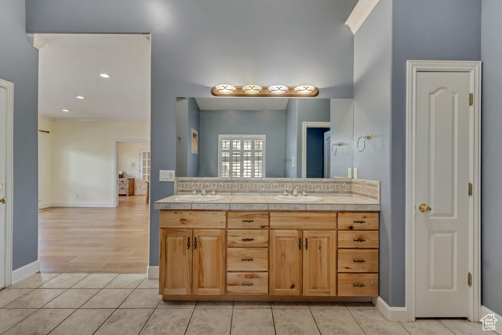 Bathroom with a sink, baseboards, and double vanity