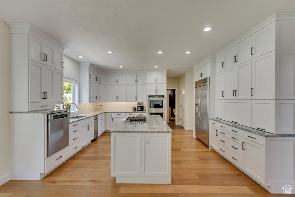 Kitchen with recessed lighting, white cabinetry, a kitchen island, and stainless steel appliances
