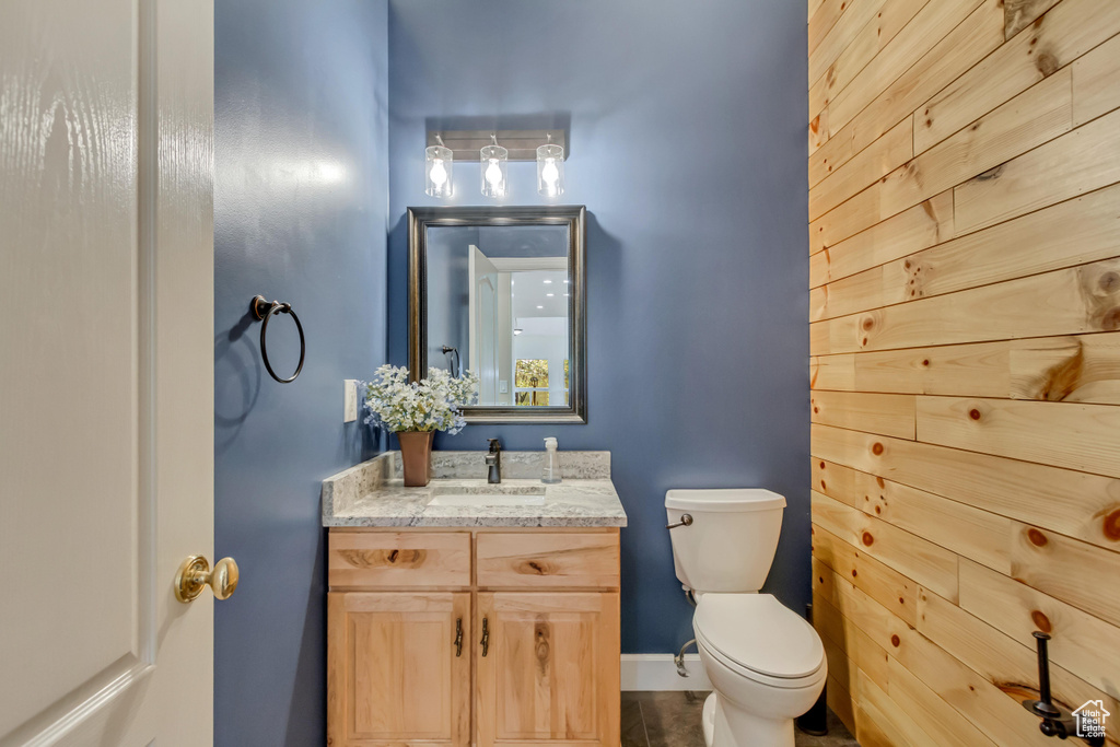 Bathroom with vanity, baseboards, tile patterned floors, and toilet