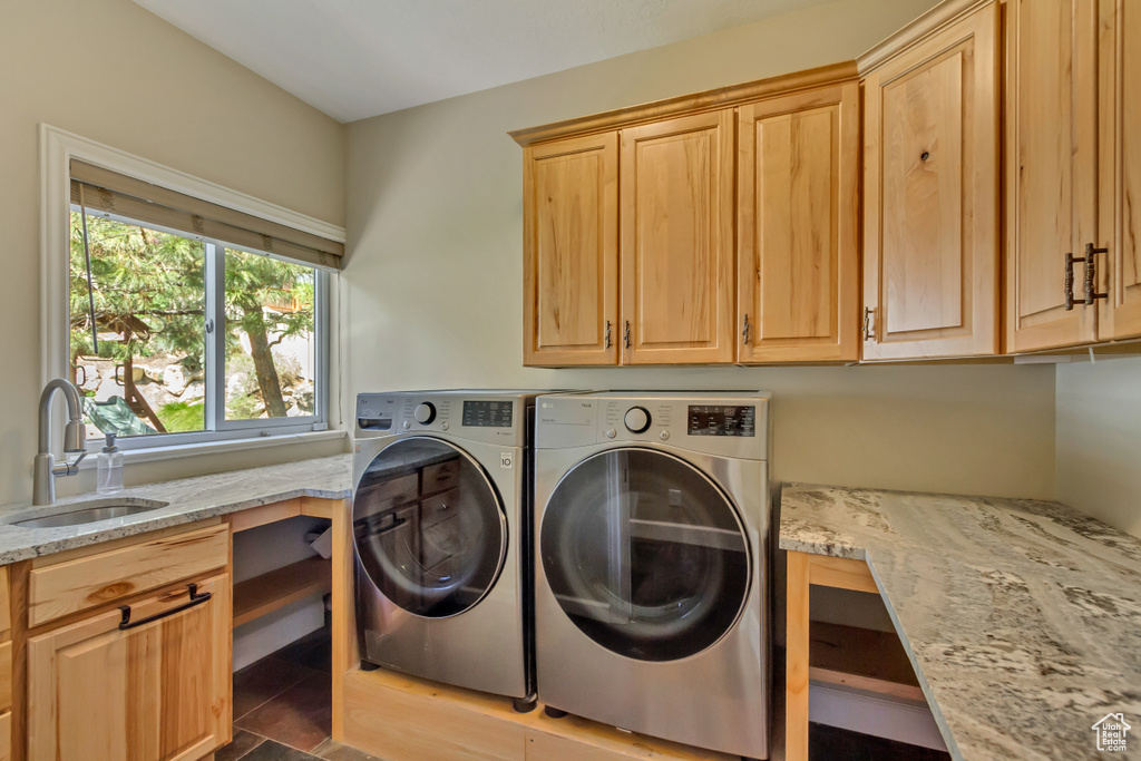 Clothes washing area with cabinet space, washing machine and dryer, and a sink