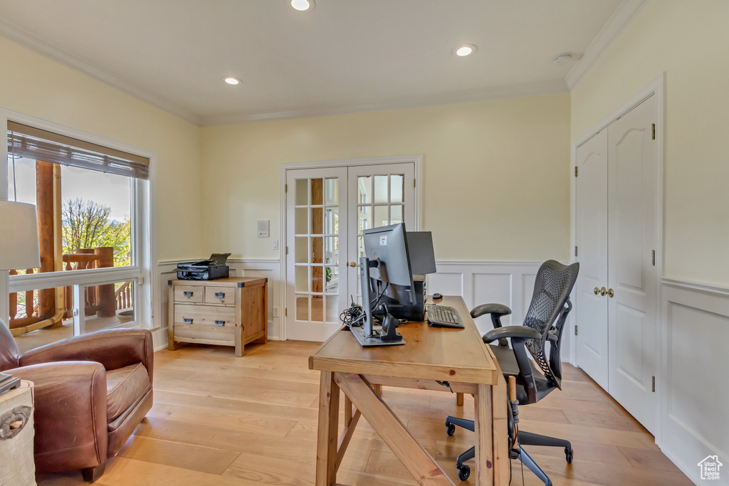 Home office with french doors, wainscoting, crown molding, and light wood-style floors