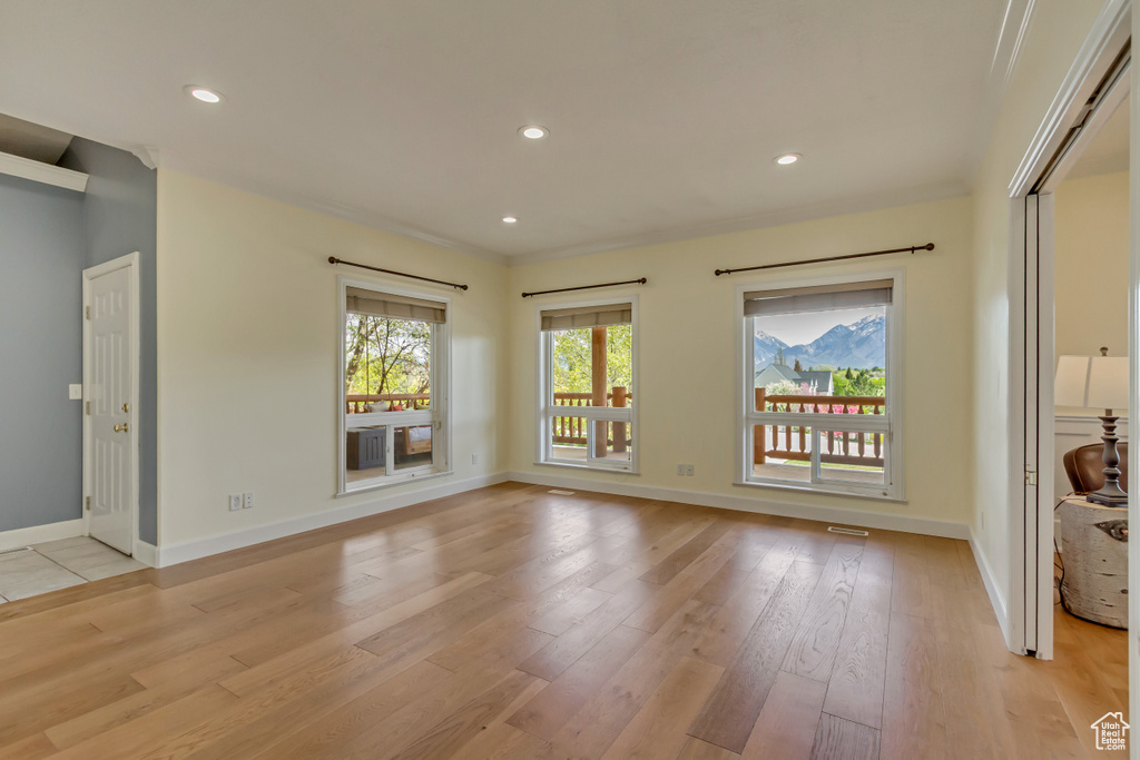 Empty room featuring recessed lighting, baseboards, and light wood-type flooring
