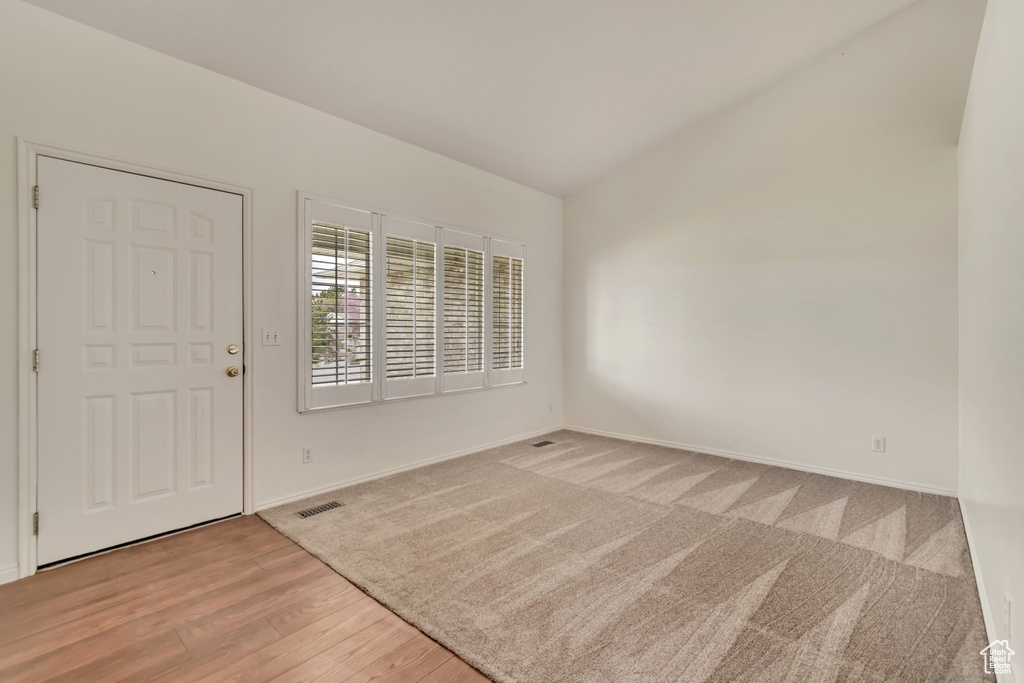 Entryway featuring baseboards, visible vents, wood finished floors, and lofted ceiling