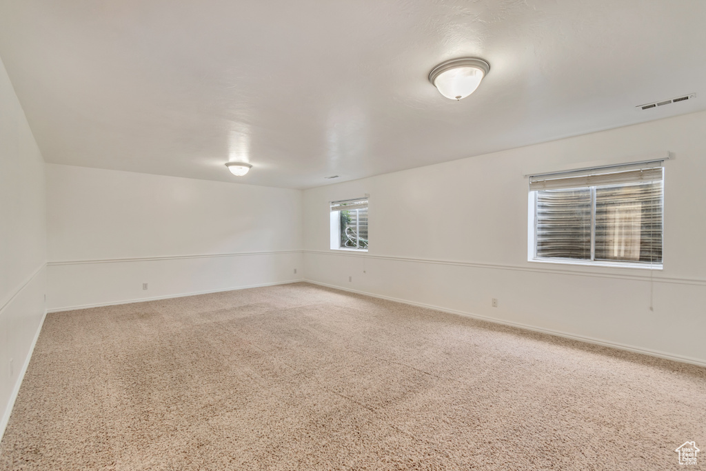 Unfurnished room with baseboards, carpet flooring, and visible vents