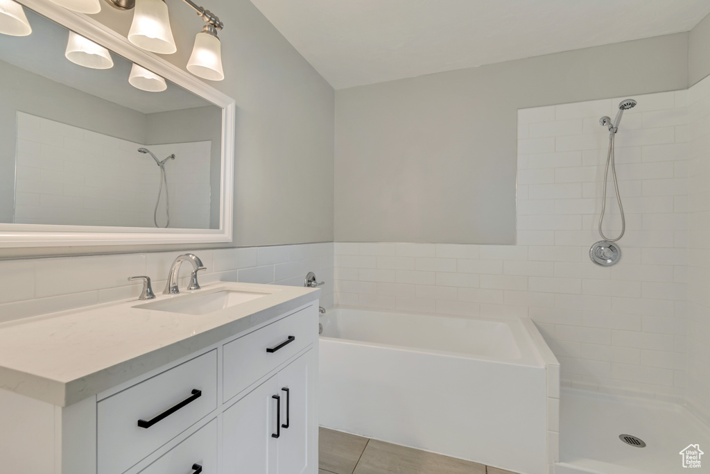 Bathroom with vanity, tile patterned flooring, a tile shower, and a bath