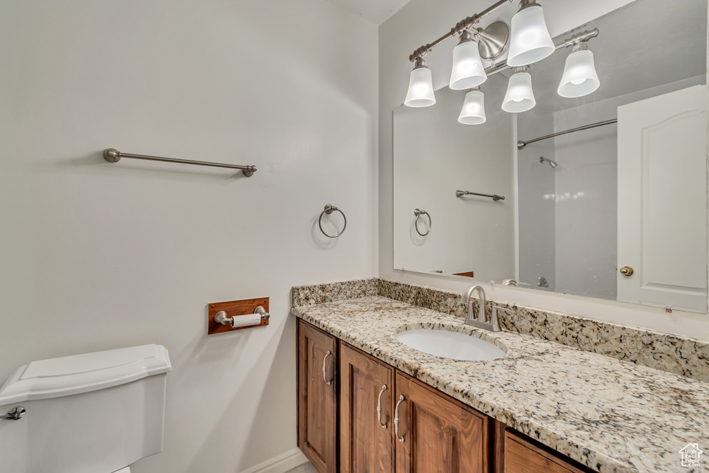 Bathroom featuring vanity, baseboards, and toilet