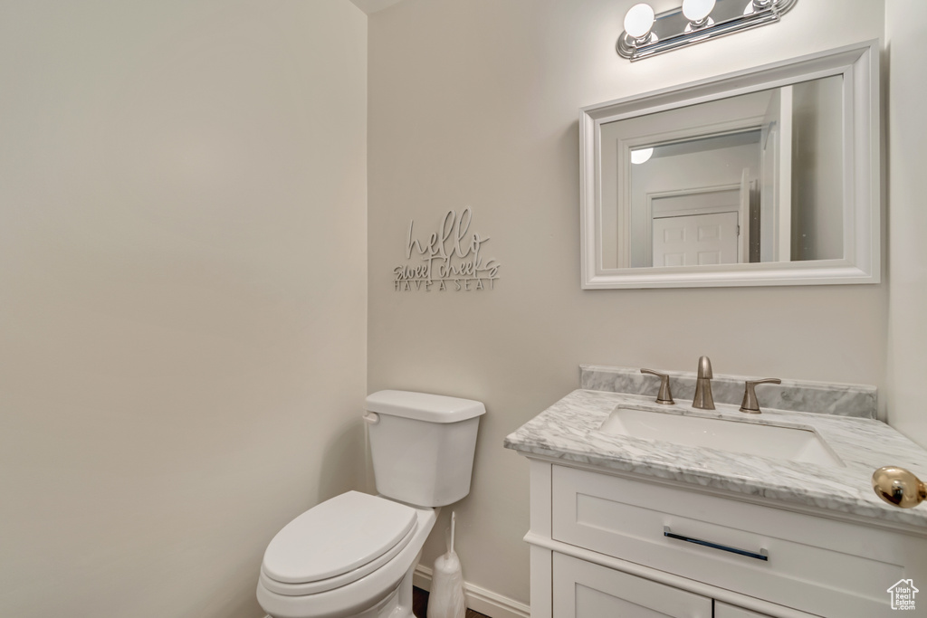 Bathroom featuring vanity, baseboards, and toilet