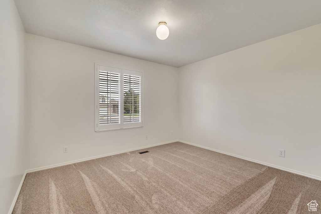Carpeted spare room with baseboards