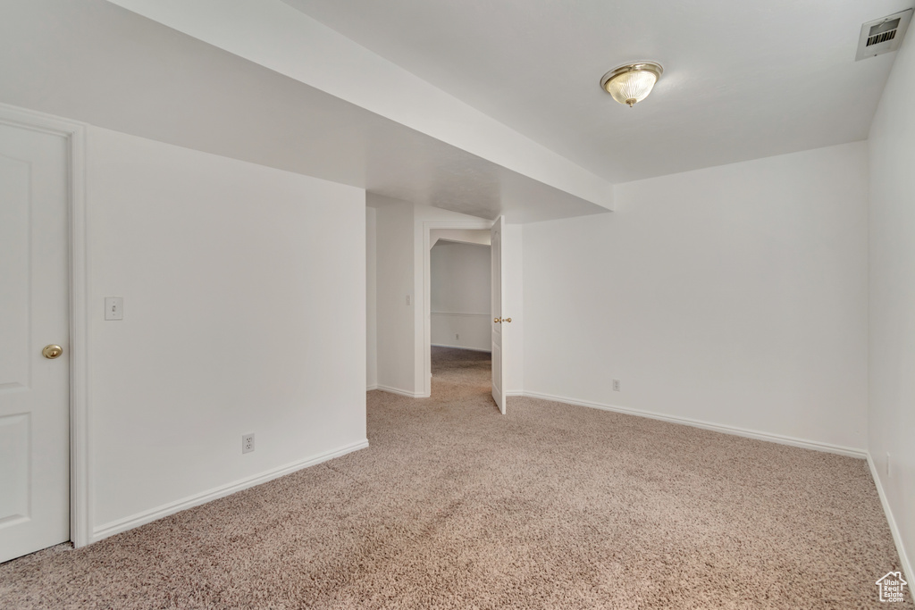 Empty room with visible vents, baseboards, and light colored carpet