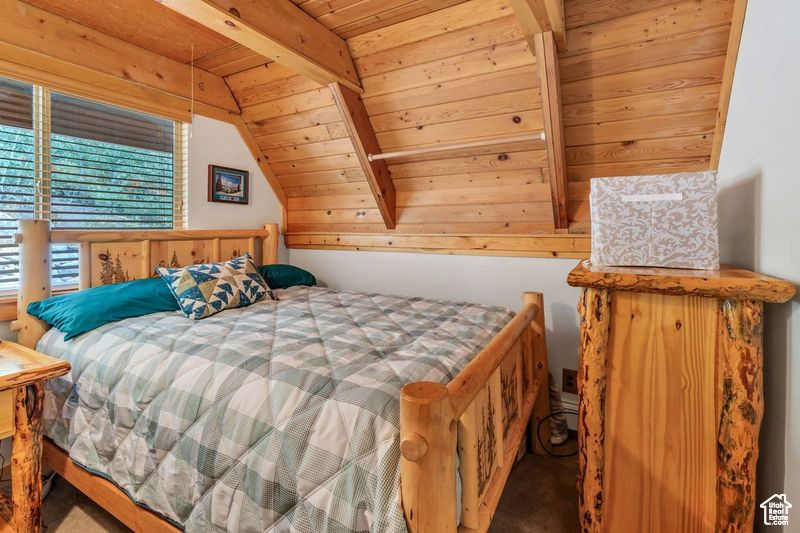 Bedroom featuring carpet floors, wood ceiling, and vaulted ceiling