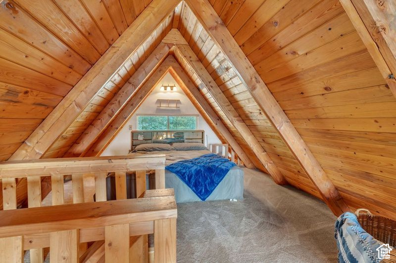 Unfurnished bedroom featuring carpet flooring, wood ceiling, and lofted ceiling