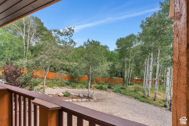 View of yard with fence and a balcony