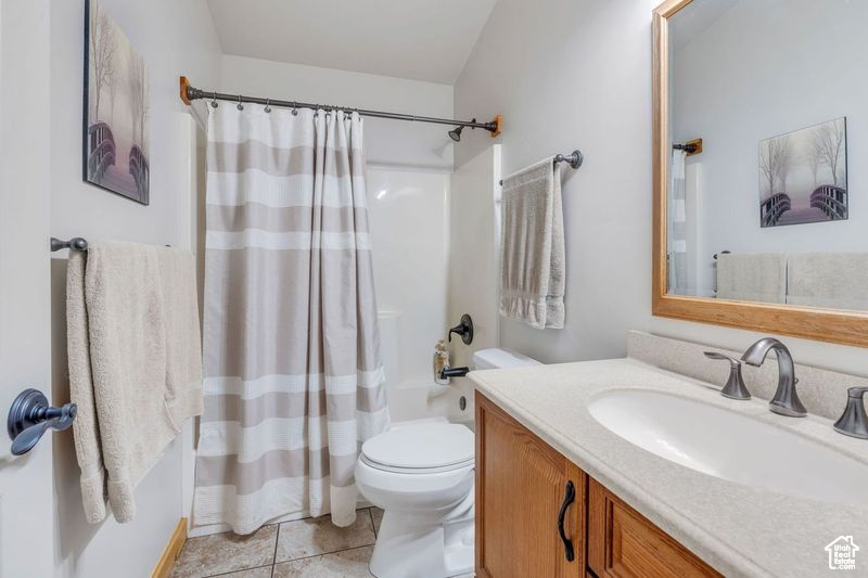 Bathroom featuring toilet, tile patterned floors, shower / tub combo, and vanity