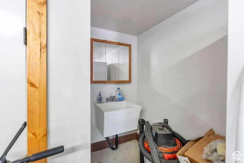 Bathroom featuring baseboards and a sink