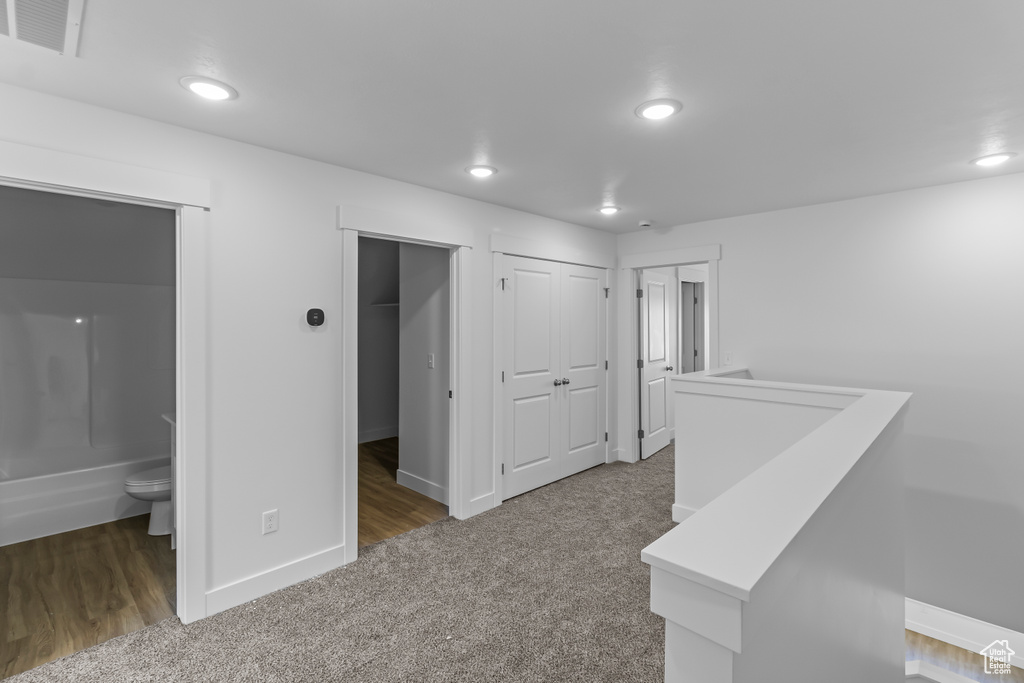 Hallway with baseboards, carpet flooring, recessed lighting, and visible vents