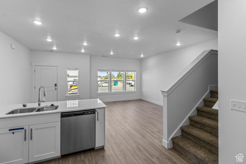 Kitchen with stainless steel dishwasher, recessed lighting, white cabinets, and a sink