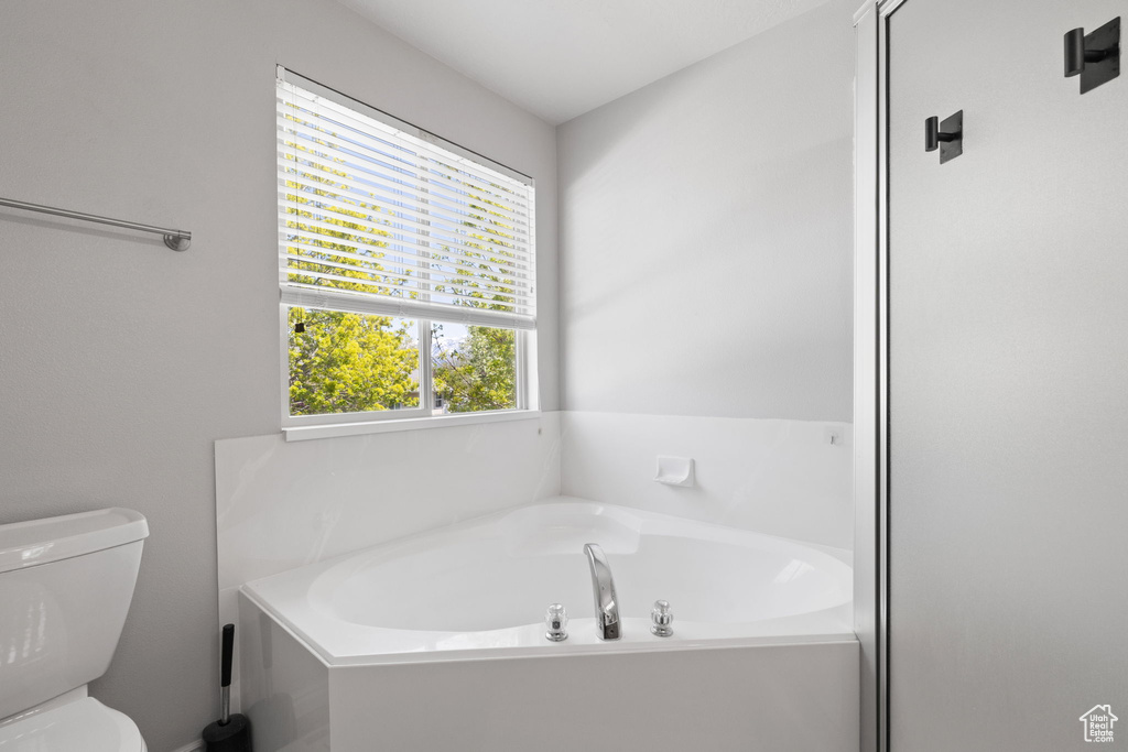 Bathroom with a garden tub and toilet