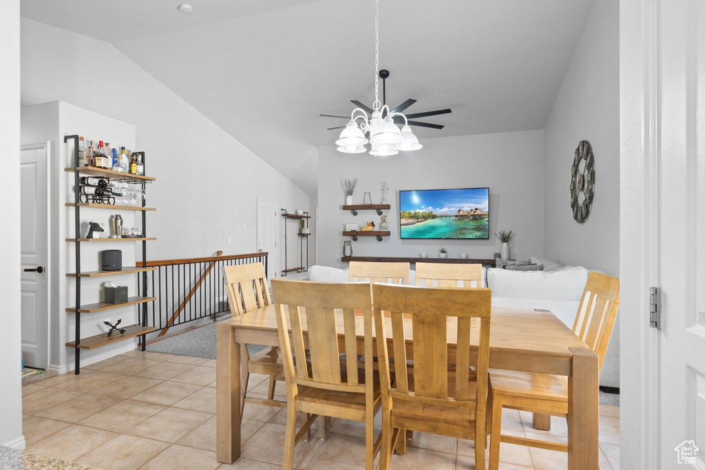 Dining area featuring ceiling fan, lofted ceiling, and light tile patterned flooring