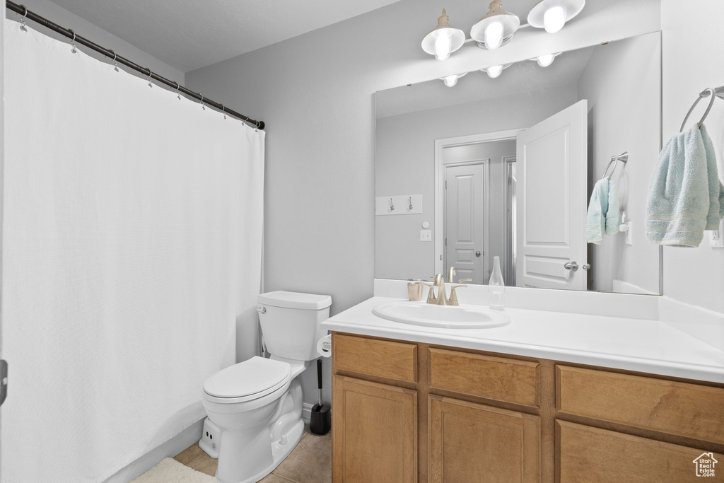 Full bath with tile patterned flooring, toilet, and vanity