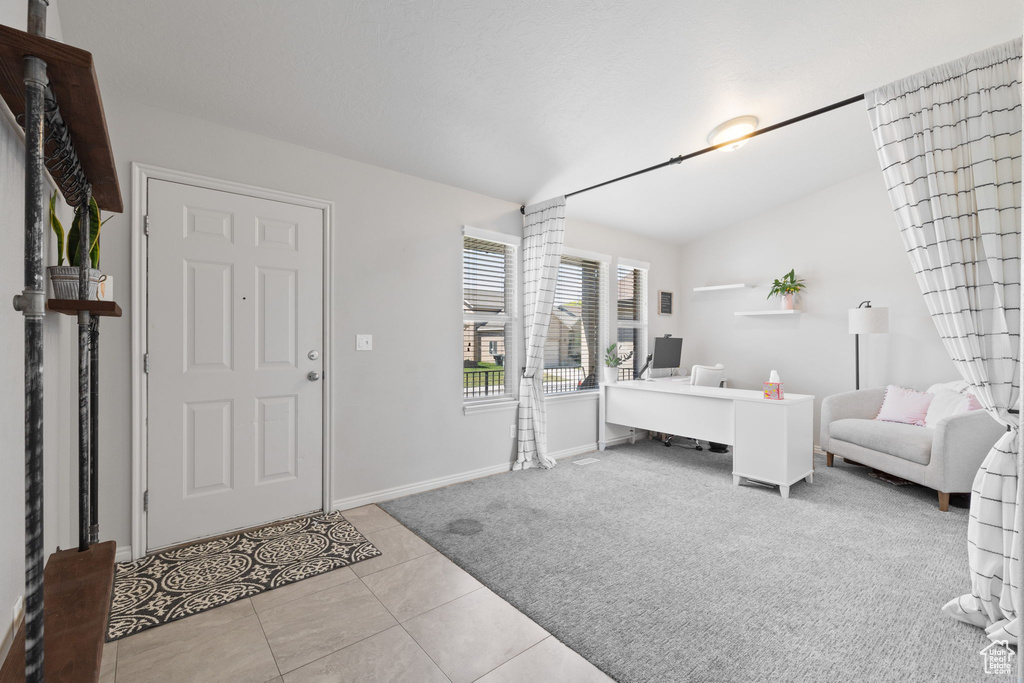 Bedroom featuring lofted ceiling, tile patterned floors, and baseboards