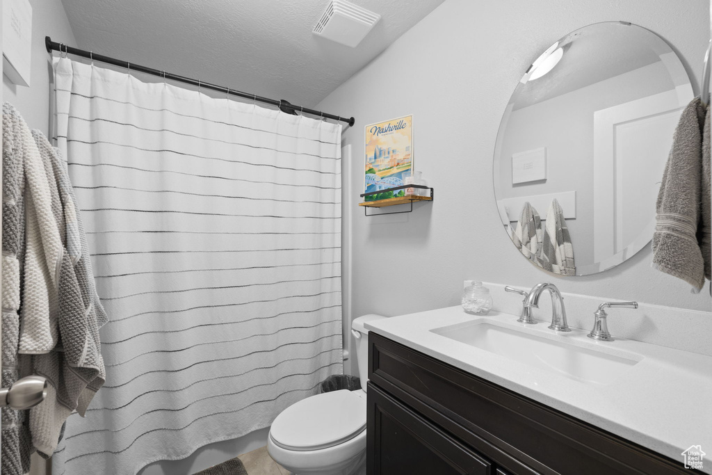 Bathroom with visible vents, curtained shower, vanity, and toilet