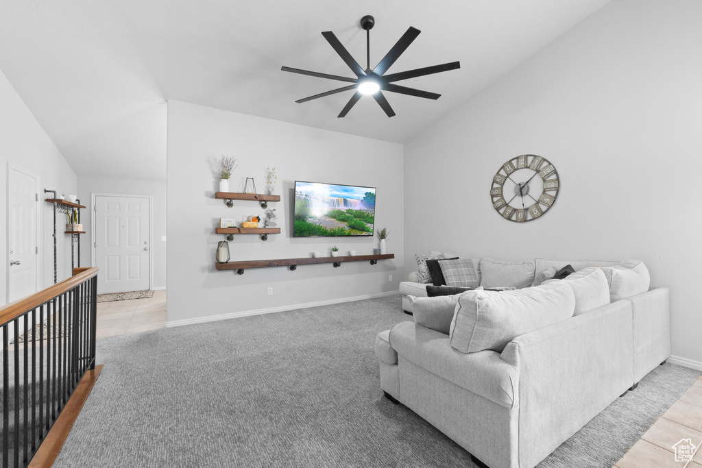 Living area featuring vaulted ceiling, a ceiling fan, tile patterned floors, and baseboards