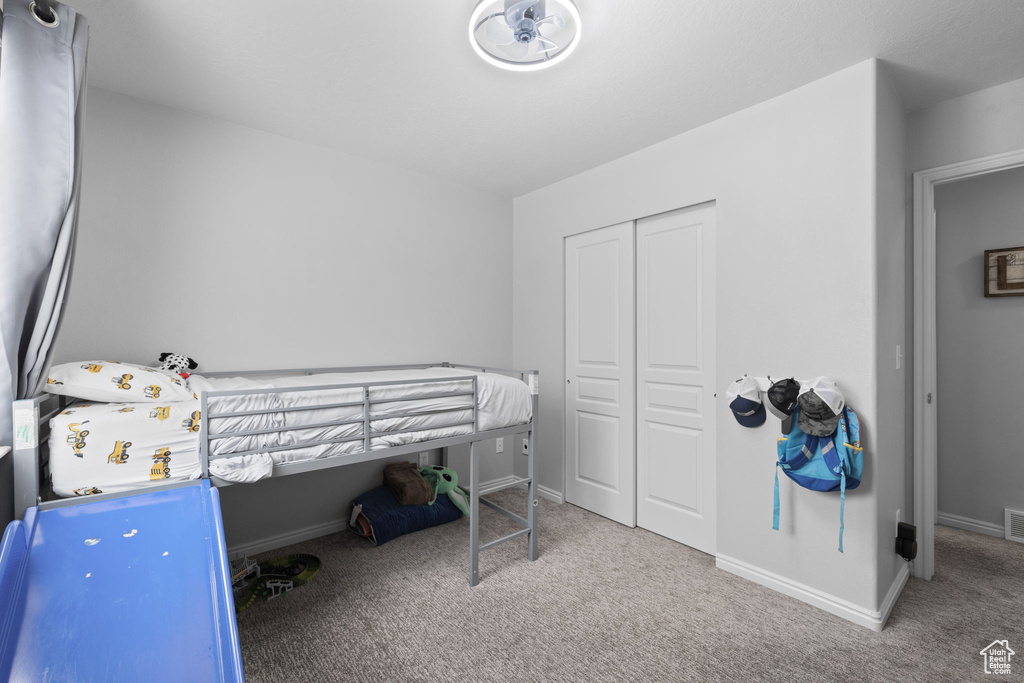 Carpeted bedroom with a closet, baseboards, and visible vents