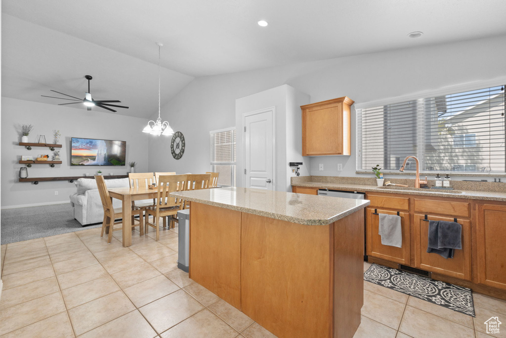 Kitchen with vaulted ceiling, a center island, a sink, ceiling fan with notable chandelier, and light tile patterned floors