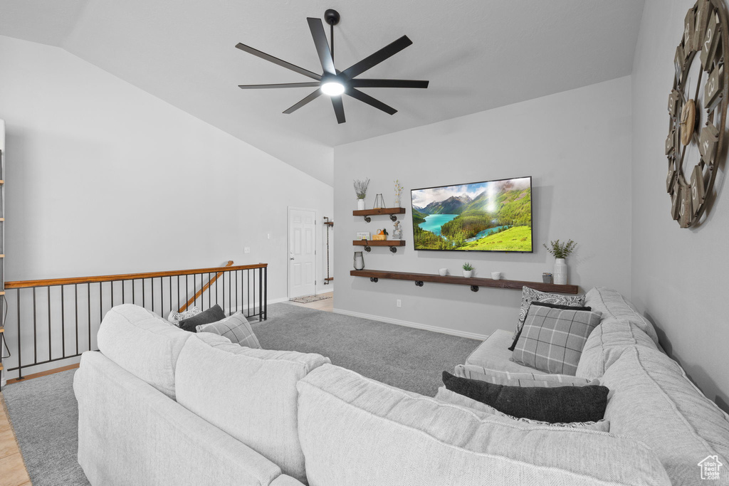 Living room with vaulted ceiling, baseboards, and ceiling fan