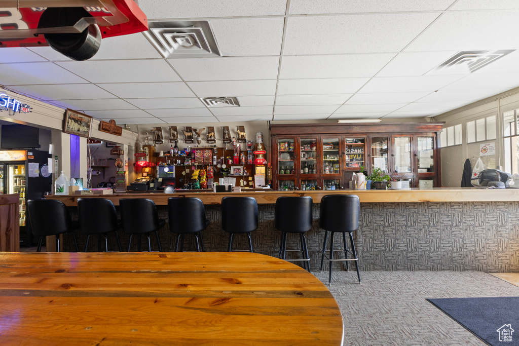 Bar featuring visible vents, carpet, a paneled ceiling, and a dry bar