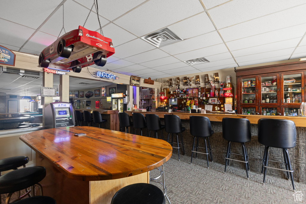 Bar with visible vents, a drop ceiling, and a bar