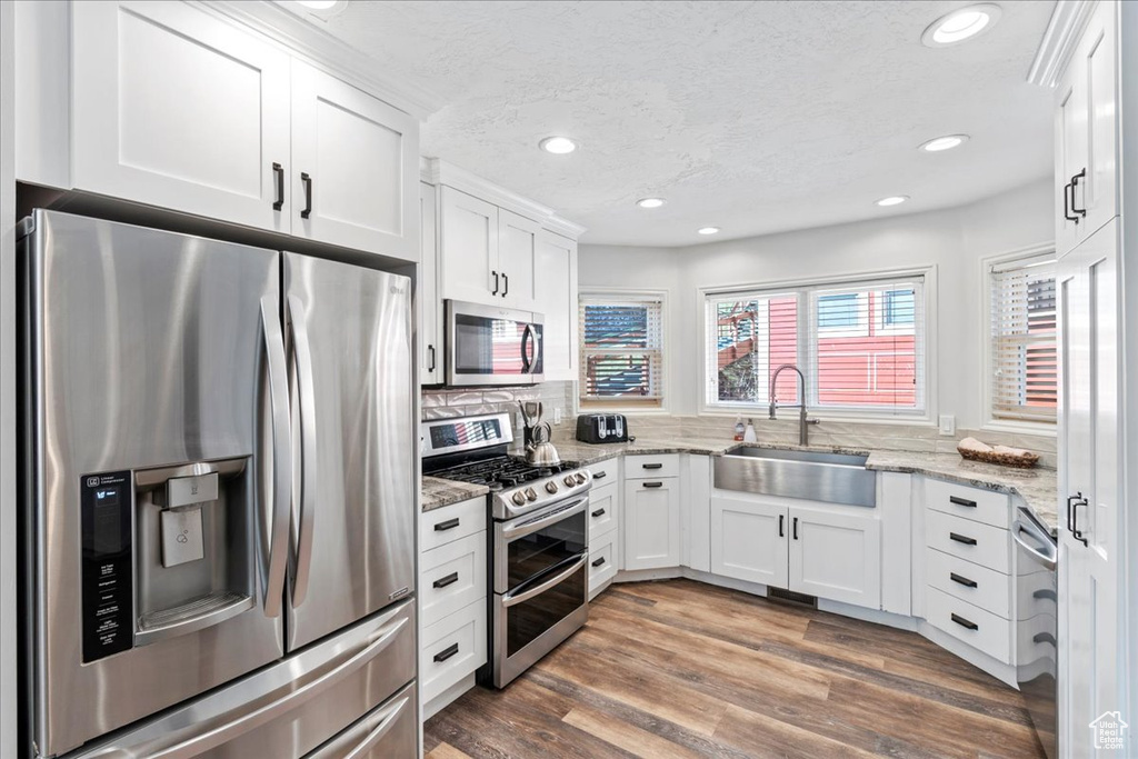 Kitchen featuring recessed lighting, a sink, white cabinetry, and stainless steel appliances