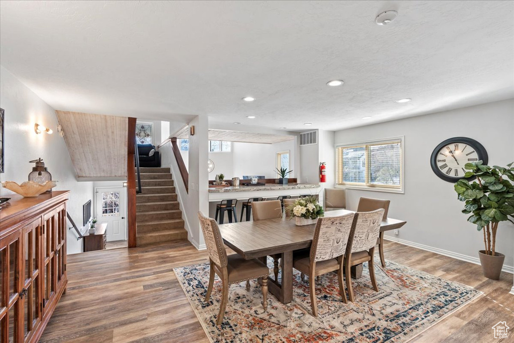 Dining room with stairs, recessed lighting, baseboards, wood finished floors, and visible vents