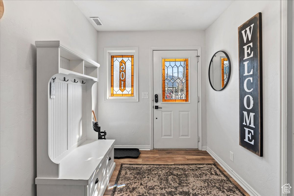 Mudroom with baseboards, visible vents, and wood finished floors