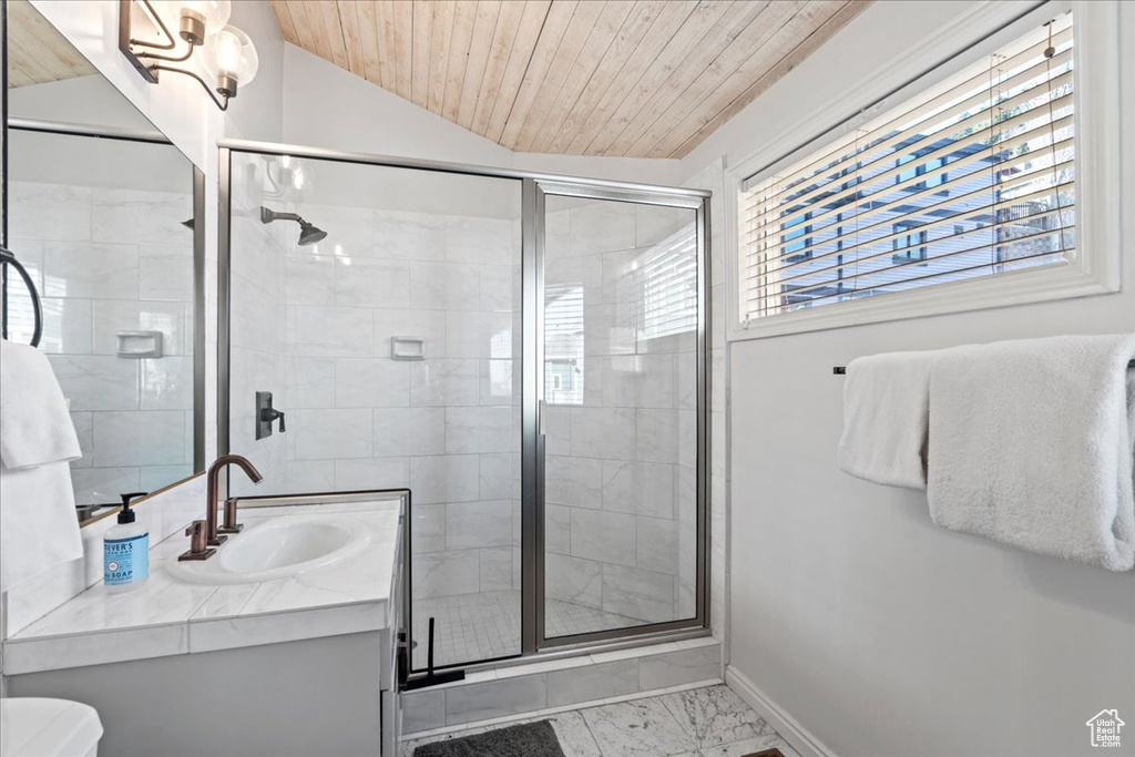 Bathroom featuring vanity, marble finish floor, baseboards, wooden ceiling, and a stall shower