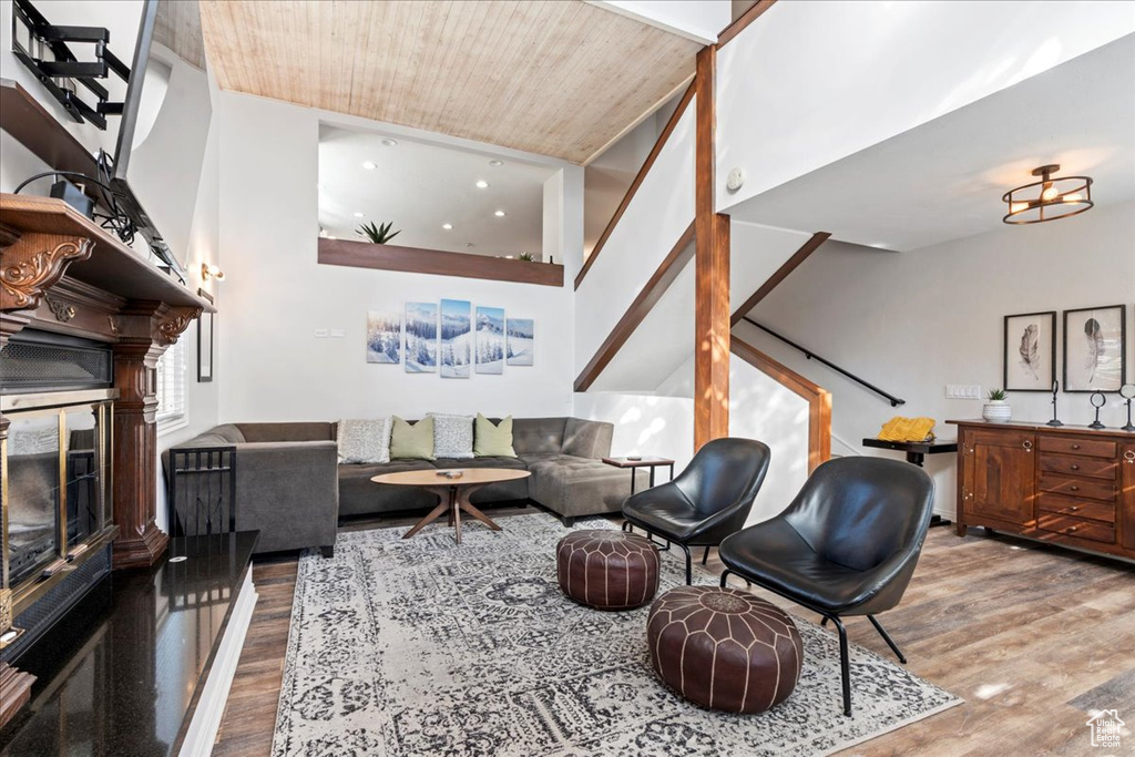 Living room with wood ceiling, a fireplace, stairs, and wood finished floors
