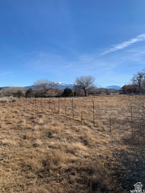 View of yard featuring a mountain view, fence, and a rural view