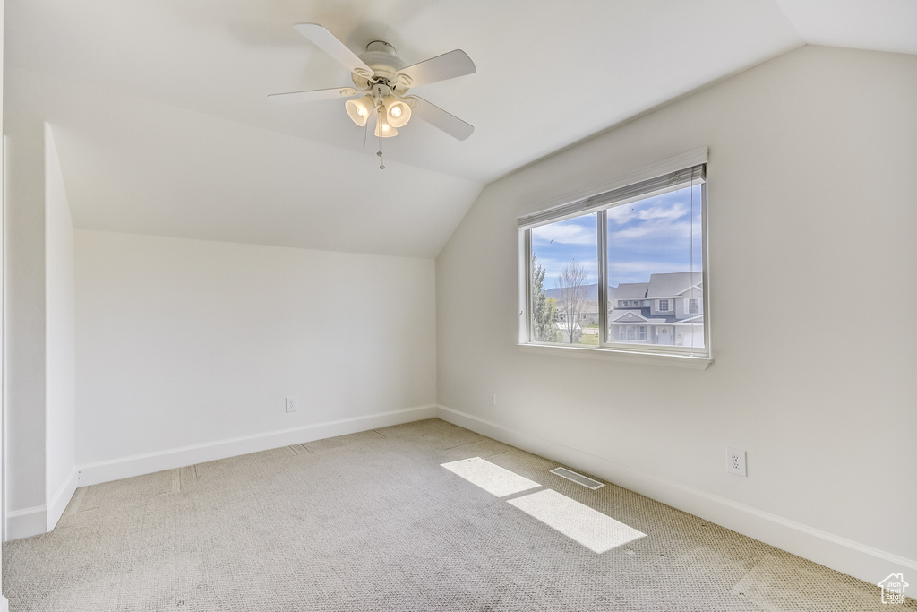 Bonus room featuring carpet flooring, ceiling fan, visible vents, vaulted ceiling, and baseboards