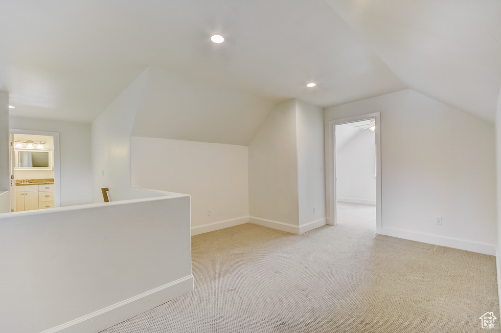 Additional living space featuring recessed lighting, vaulted ceiling, light colored carpet, and baseboards