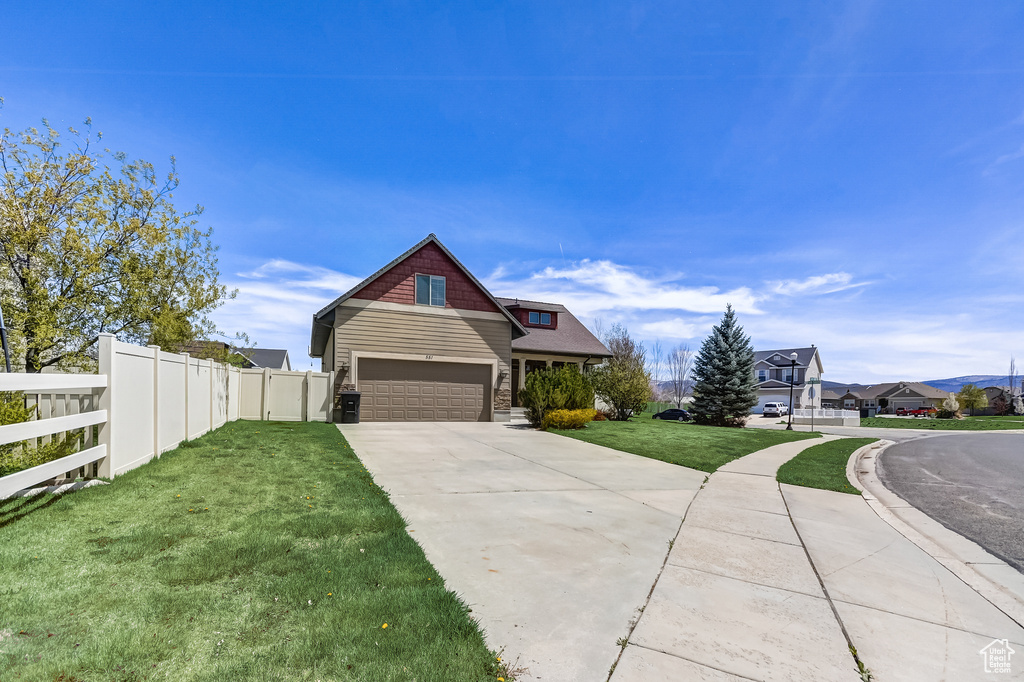 Craftsman house featuring fence, a front yard, and concrete driveway