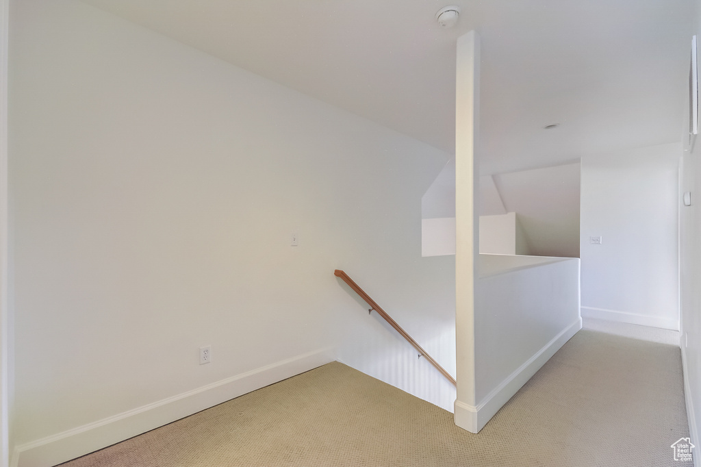 Stairway with lofted ceiling, carpet, and baseboards