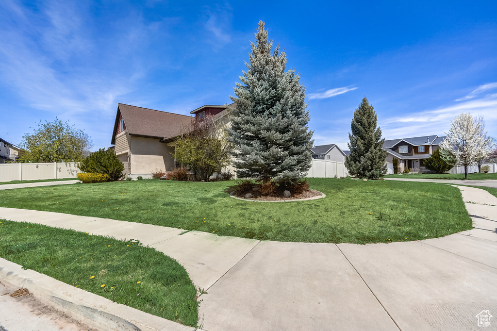 View of front of home featuring a residential view, a front yard, and fence