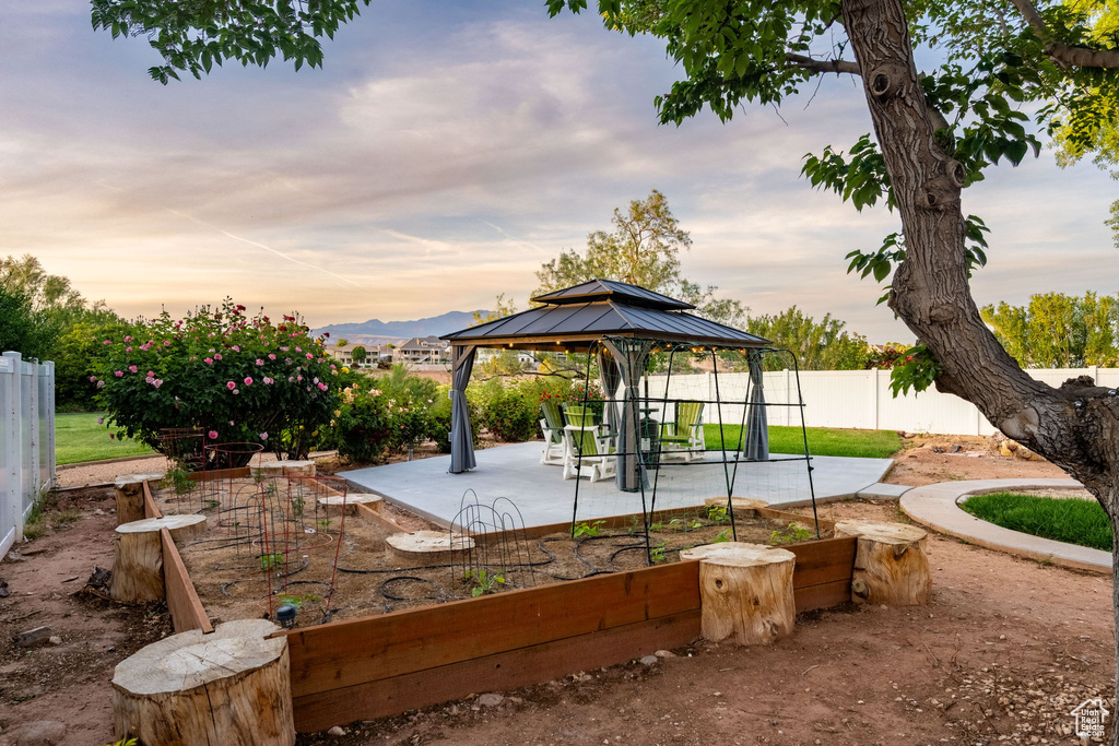 View of property's community featuring a gazebo, a mountain view, fence private yard, and a patio area