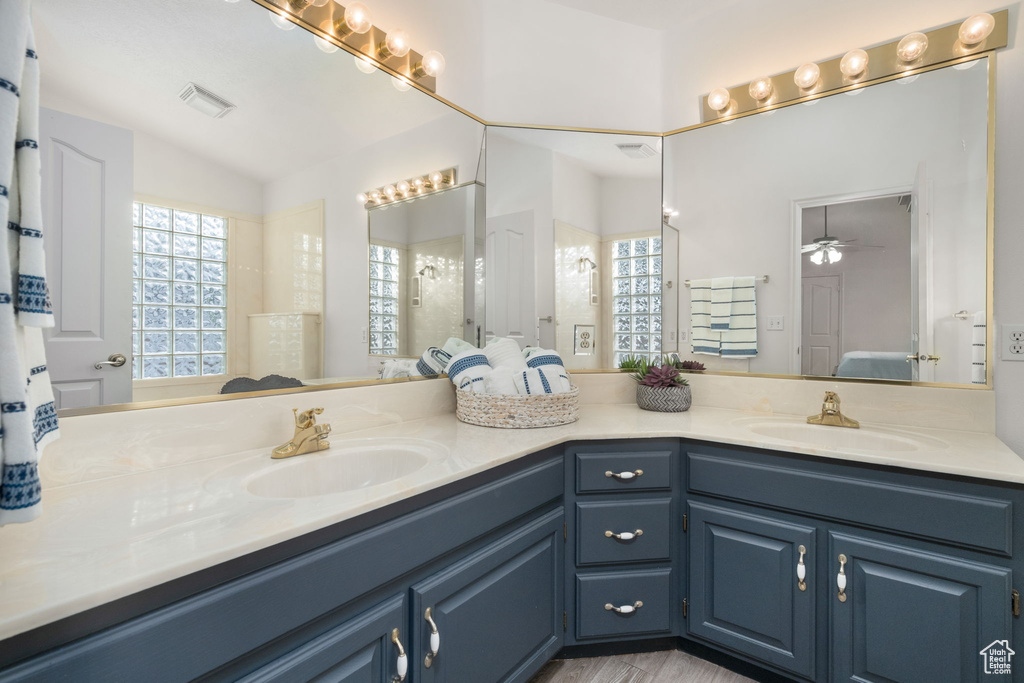 Full bathroom with double vanity, visible vents, and a sink