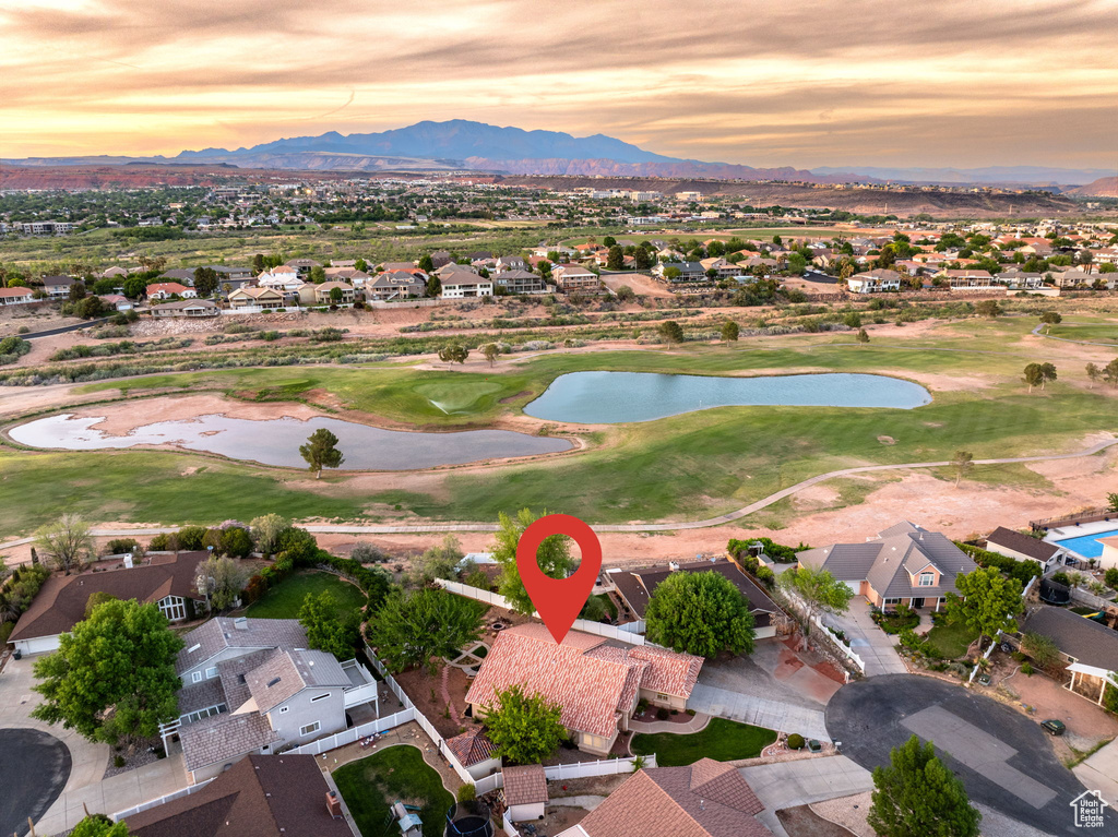 Aerial view at dusk with view of golf course, a residential view, and a water and mountain view