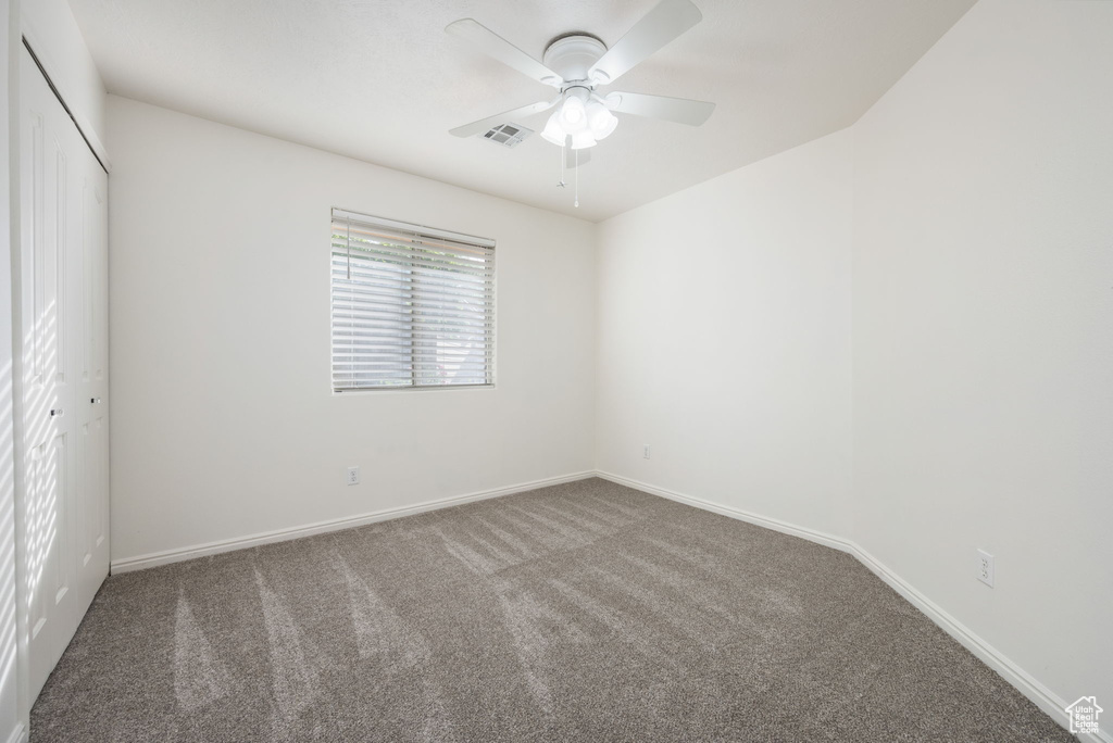 Unfurnished bedroom featuring carpet flooring, baseboards, visible vents, and a closet