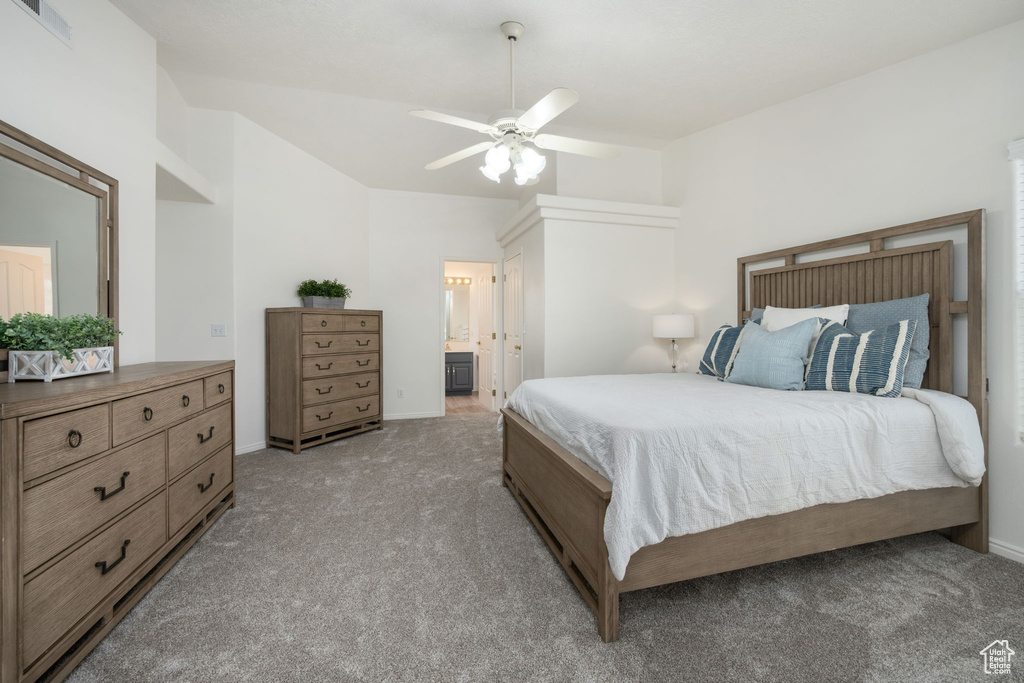 Bedroom featuring light carpet, ensuite bath, baseboards, vaulted ceiling, and visible vents