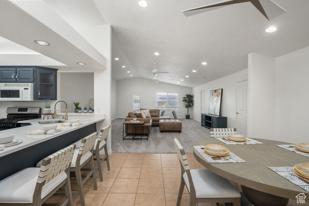Dining space with recessed lighting, ceiling fan, and light carpet