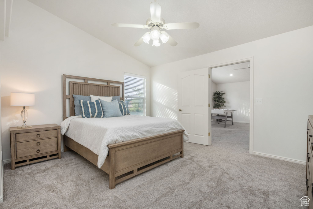 Carpeted bedroom with baseboards, ceiling fan, and vaulted ceiling